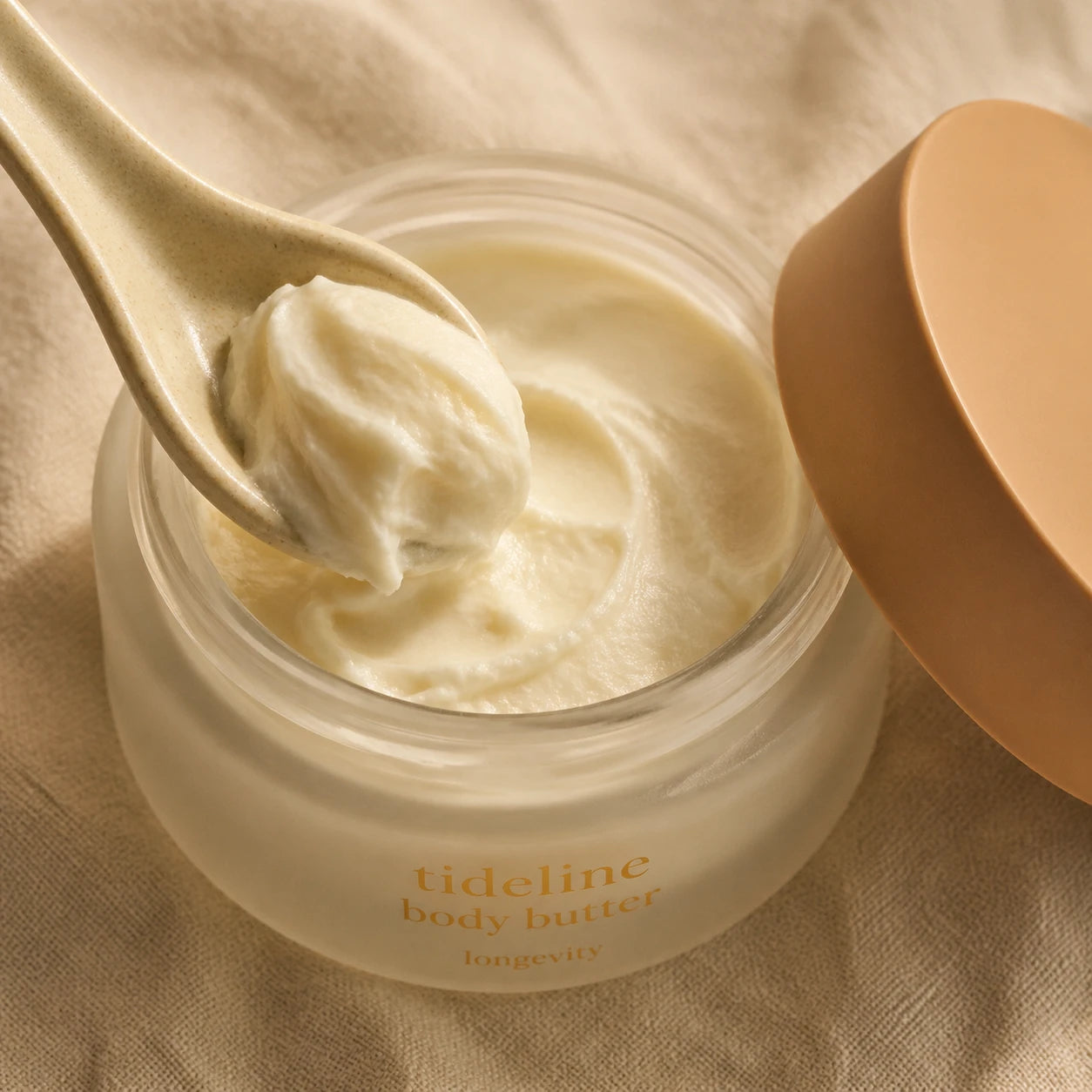 Macro of pale ivory whipped butter being scooped with a ceramic spoon