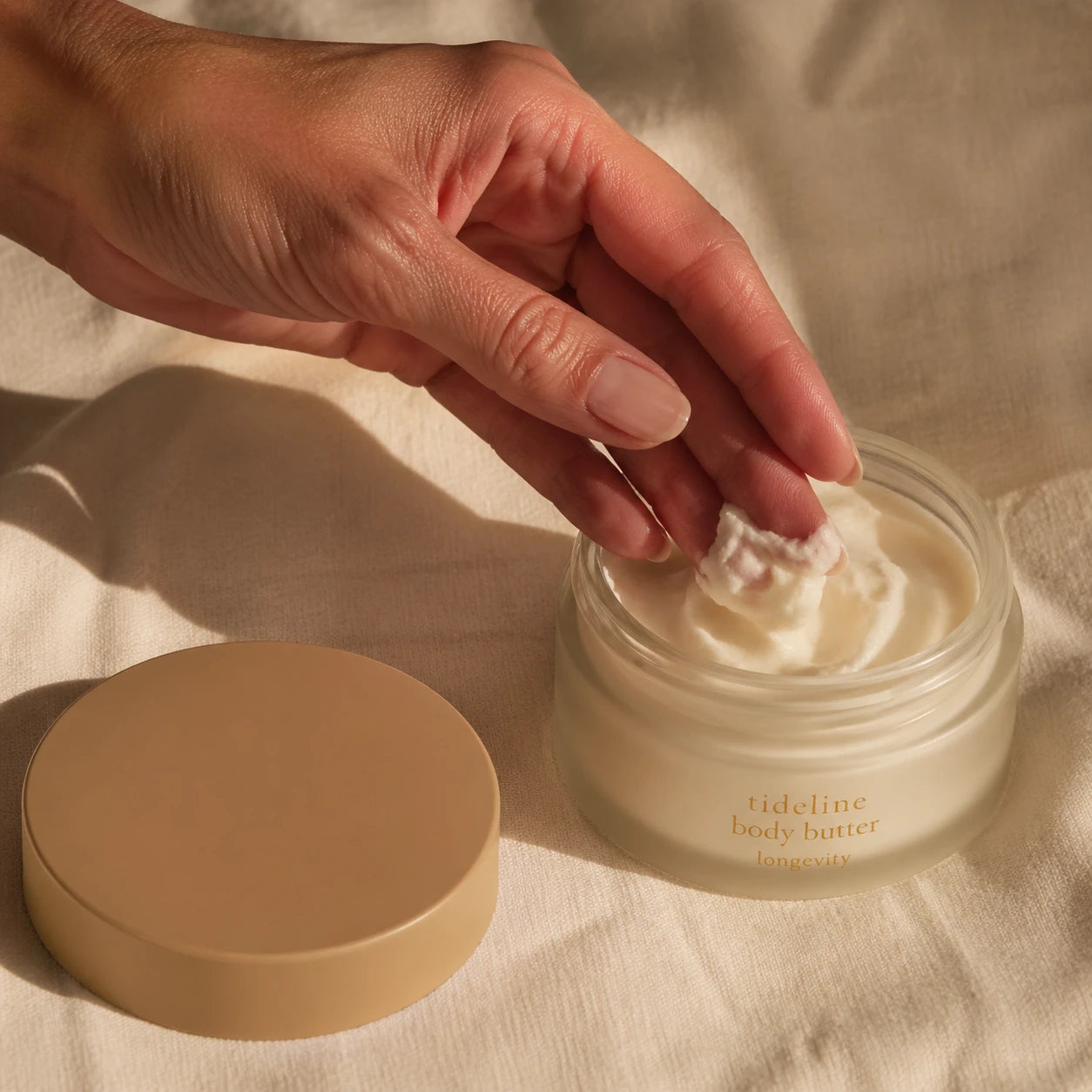 Hand scooping body butter from the jar